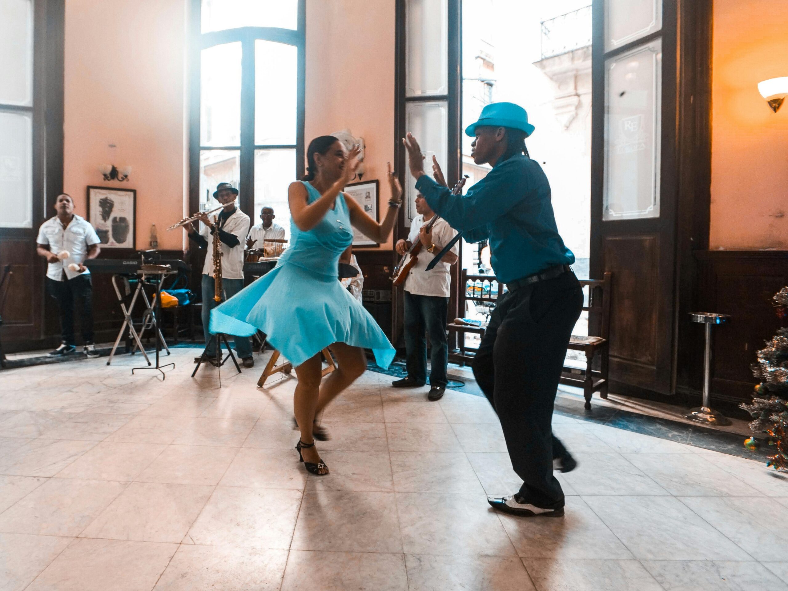Home A lively dance performance capturing joy and rhythm in a bustling café with live musicians.