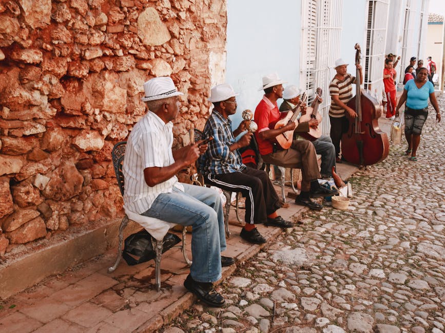 Home A group of street musicians playing various instruments in a quaint cobblestone alley.